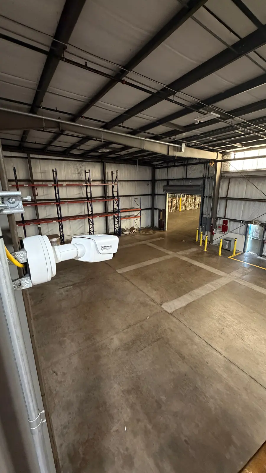 A camera mounted inside a warehouse covering the loading dock doors.