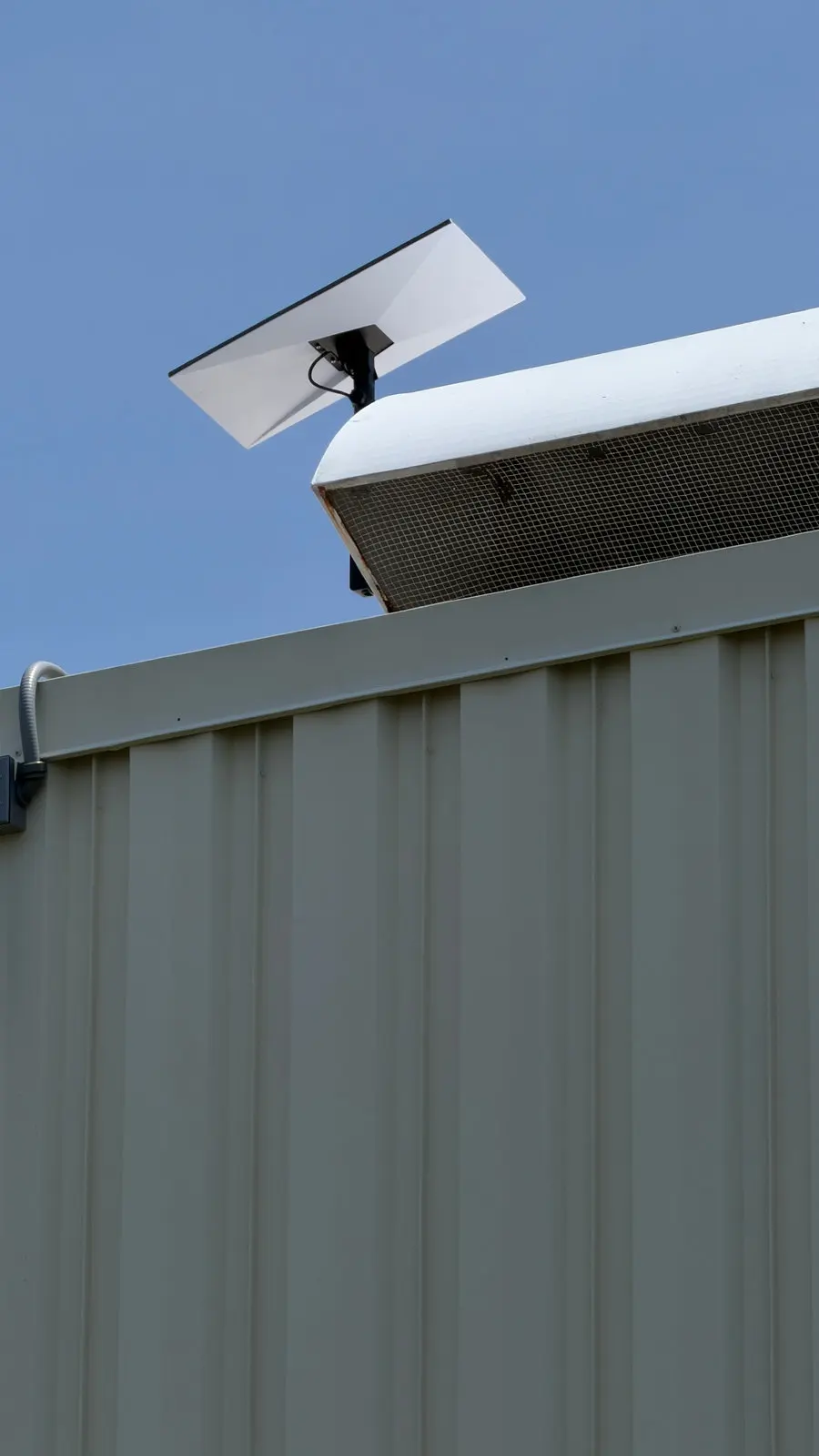 A Starlink dish mounted on the roof edge of a commercial building.